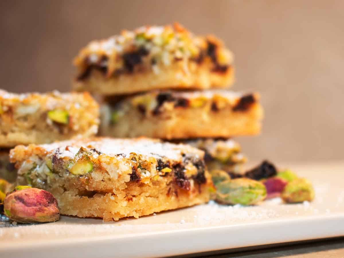 Close up of Sour Cherry and Pistachio Slices next to dried cherries and pistachio